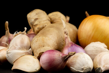 Whole group pile ingredient of fresh onion garlic ginger group isolated on black background