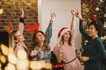 Fototapeta na wymiar Four Multi Ethnic Female Friends Having Fun And Dancing At Home Christmas Party