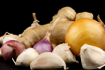 Whole group pile ingredient of fresh onion garlic ginger group isolated on black background