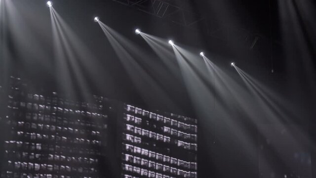 Animation of stage lights frame. Bright shiny stage lights flashing movement entertainment spotlight projectors in the dark, multicolored soft light spotlight strike on black background.