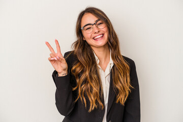 Young caucasian business woman isolated on white background joyful and carefree showing a peace symbol with fingers.