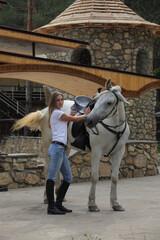 Fototapeta na wymiar Beautiful equestrian girl posing with white horse in the ranch