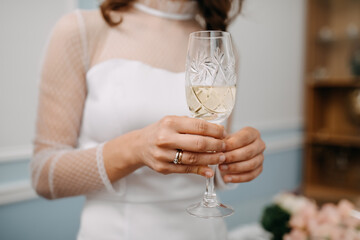 Closeup of bride hand holding a crystal glass of champagne.
