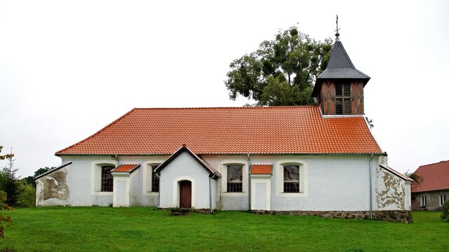 General view and architectural details of the Protestant church built in plastered red brick at the beginning of the 19th century in the village of Rańsk in Masuria, Poland.