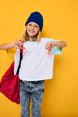 cheerful girl in a white t-shirt school backpack hand gesture