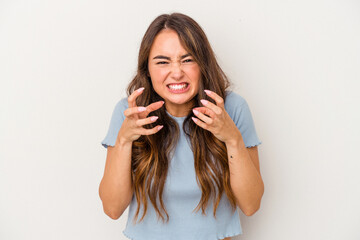 Young caucasian woman isolated on white background upset screaming with tense hands.