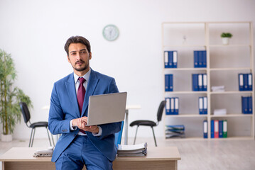 Young male employee working at workplace