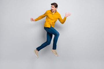 Full length body size view of attractive cheery amazed worried man jumping going isolated over grey color background