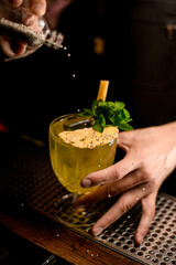 beautiful glass with drink decorated with mint and dried flower petal which sprinkled by edible balls