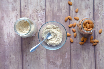 Fototapeta na wymiar almond powder and almond in a jar on table,