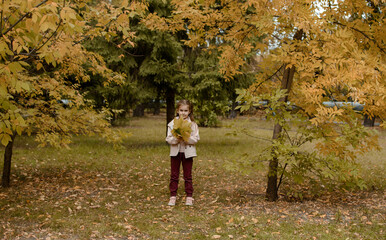 Fototapeta premium Close-up portrait of pretty little girl resting in autumnal park.