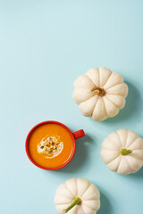 Autumn pumpkins soup with vegetables on blue background