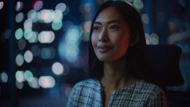 Beautiful Asian Female Portrait Working on Desktop Computer in Dark Modern Office. Businesswoman Works at Home Late in the Evening. Adult Woman Using Social Media, Typing Email, Chatting with Friends.