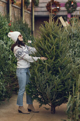 Cute brunette in a white sweater with Christmas tree