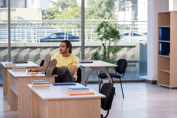 Young male student sitting in the classroom