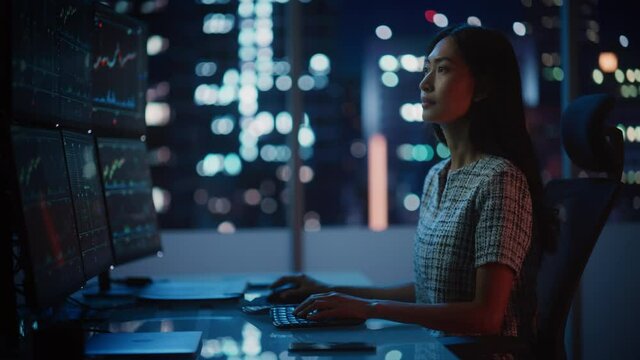 Portrait of a Financial Analyst Working on Computer with Multi-Monitor Workstation with Real-Time Stocks, Commodities and Exchange Market Charts. Businesswoman at Work in Investment Broker Agency.