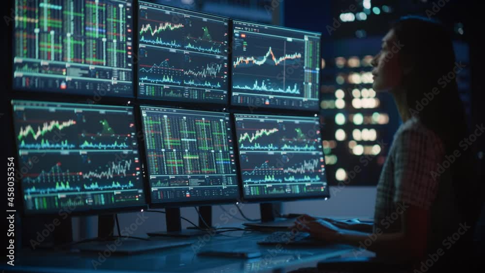 Poster portrait of a financial analyst working on computer with multi-monitor workstation with real-time st