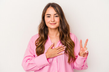 Young caucasian woman isolated on white background taking an oath, putting hand on chest.
