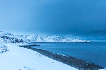 Russia, Kola peninsula, Murmansk region, the village of Teriberka. The rocky coast of the cold Barents Sea beyond the Arctic Circle in the far North in winter frosts.