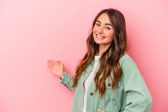 Young caucasian woman isolated on pink background showing a welcome expression.