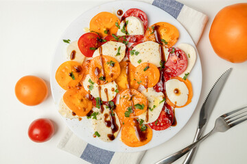 Fresh classic italian caprese salad with sliced red yellow tomatoes, mozzarella, olive oil, pepper and salt on light background. Vegan food. Top view. Flat lay