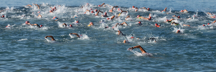 Large group of people in swimming at triathlon - obrazy, fototapety, plakaty
