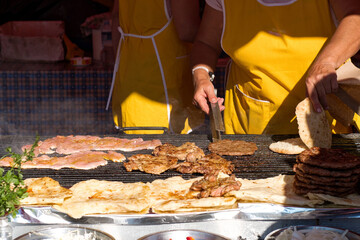 Traditional serbian street food (rostilj) - pljeskavica, cevapi, grilled chicken breast, bbq chicken wings and homemade sausages served with fresh bakery (lepinja)