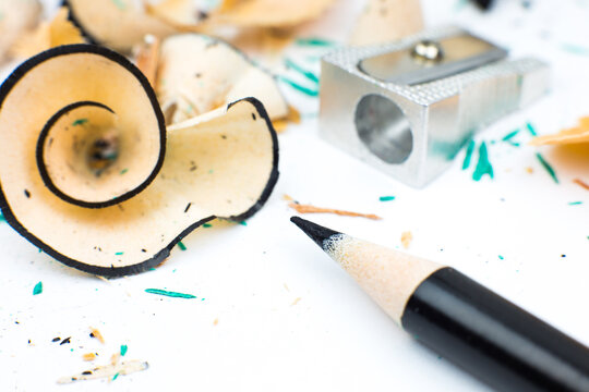 Sharpener and a broken pencil. Shavings and a graphite on white background. Close up, Macro photo. Back to school concept.