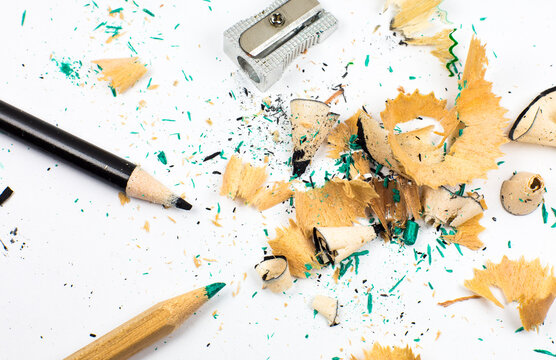 Sharpener and a broken pencil. Shavings and a graphite on white background. Close up, Macro photo. Back to school concept.
