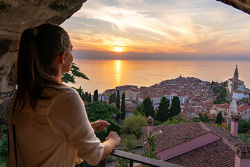 blurred tourist woman watching the beautiful sunset from the piran city walls Piransko obzidje