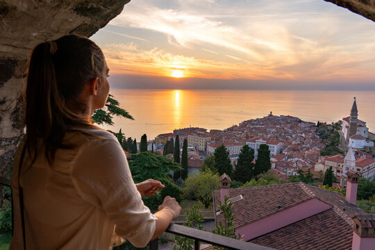 blurred tourist woman watching the beautiful sunset from the piran city walls Piransko obzidje