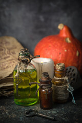 Magic potions in bottles, ancient books and witchery herbs on wooden background, Halloween theme