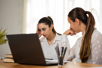 Obraz premium Mujeres de negocio preocupadas al observar su laptop mientras trabajan en su oficina.