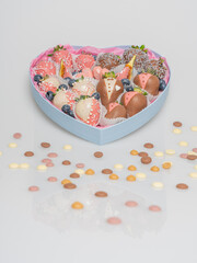 Chocolate covered strawberries for a wedding. In-line set. Heart-shaped box..Multi-colored chocolate. There is a place for the test.