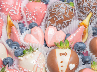 Chocolate covered strawberries for a wedding. In-line set. Heart-shaped box..Multi-colored...