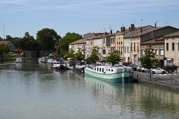 Fototapeta na wymiar Péniches amarrées sur la rive du canal du Midi à Castelnaudary