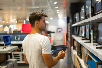 Customer choosing computer monitor in shop