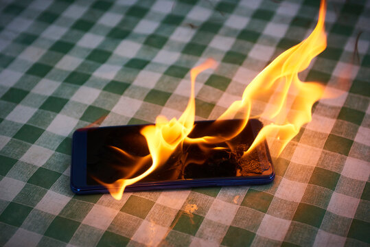 Mobile phone explodes and burns. Cell Phone explosion and fire. Smart Phone Danger from over use or bad manufacturing. Burning up overheating Smart phone concept.
