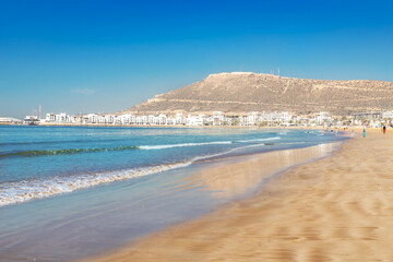 Beach and yellow sand on the coastline of Agadir in the summer season in Morocco, Africa - obrazy, fototapety, plakaty