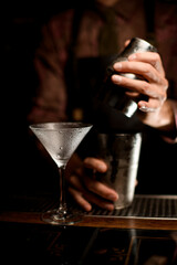 empty clean martini glass with water droplets on it stands on the bar