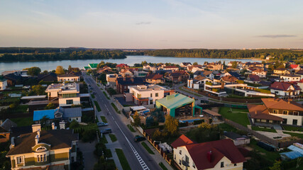 Fototapeta na wymiar Aerialphoto suburbs of big city. Country houses, forests, lakeshore. Citylife concept.