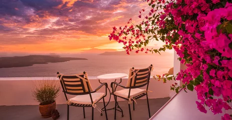 Zelfklevend Fotobehang Summer sunset vacation scenic of luxury famous Europe destination. White architecture in Santorini, Greece. Stunning travel scenery with pink flowers chairs, terrace sunny blue sky. Romantic street © icemanphotos