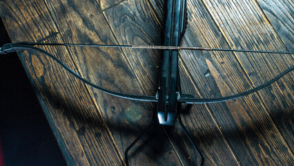Part of modern compound crossbow handgun on the dark wooden background. Old weapon concept. - obrazy, fototapety, plakaty
