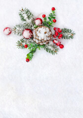 Fototapeta na wymiar Christmas decoration. Cone pine, twigs christmas tree, red berries, red balls on snow with space for text. Top view, flat lay