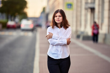 Portrait of lonely young woman on quiet city street.