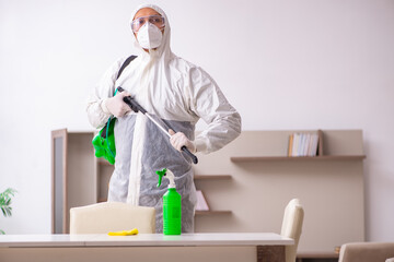 Young male contractor doing pest control at home