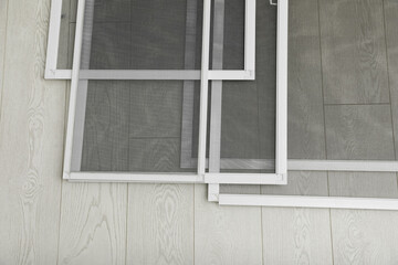 Set of window screens on wooden floor, flat lay
