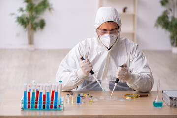 Young male chemist working at the lab during pandemic