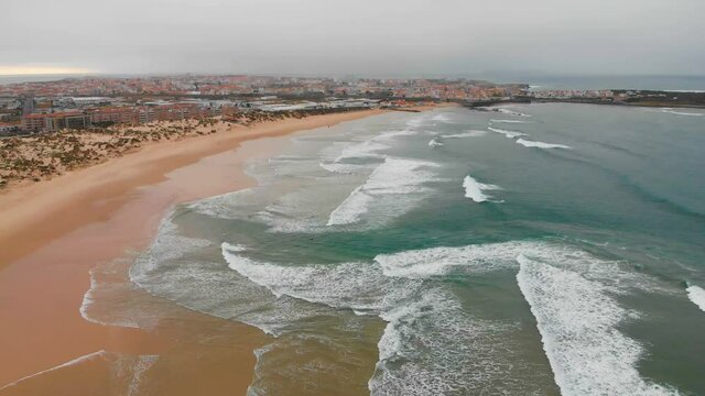 4k Aerial view of sea waves break on yellow sand beach Peniche, Portugal