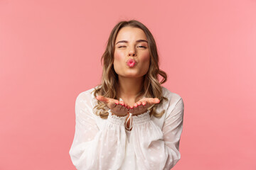 Close-up portrait of lovely feminine girlfriend enjoying spring fine day, sending air kiss at...